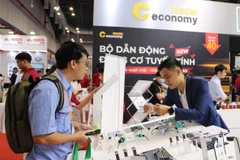 Khách tham quan quan tâm các sản phẩm công nghệ cao tại Triển lãm VIMF 2025. (Ảnh: Khánh Ly/Vietnam+)