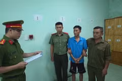 Công an Thành phố đọc Lệnh giữ khẩn cấp với đối tượng Bùi Trung Quốc ( áo xanh thứ 3 từ trái qua). (Ảnh: CA Thành phố Hồ Chí Minh cung cấp)