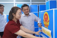 Ông Lê Lợi (trái), Phó Chủ tịch Ủy ban bầu cử phường Phú Thuận kiểm tra tiến độ công tác bầu cử tại địa phương. (Ảnh: Khánh Ly/Vietnam+)