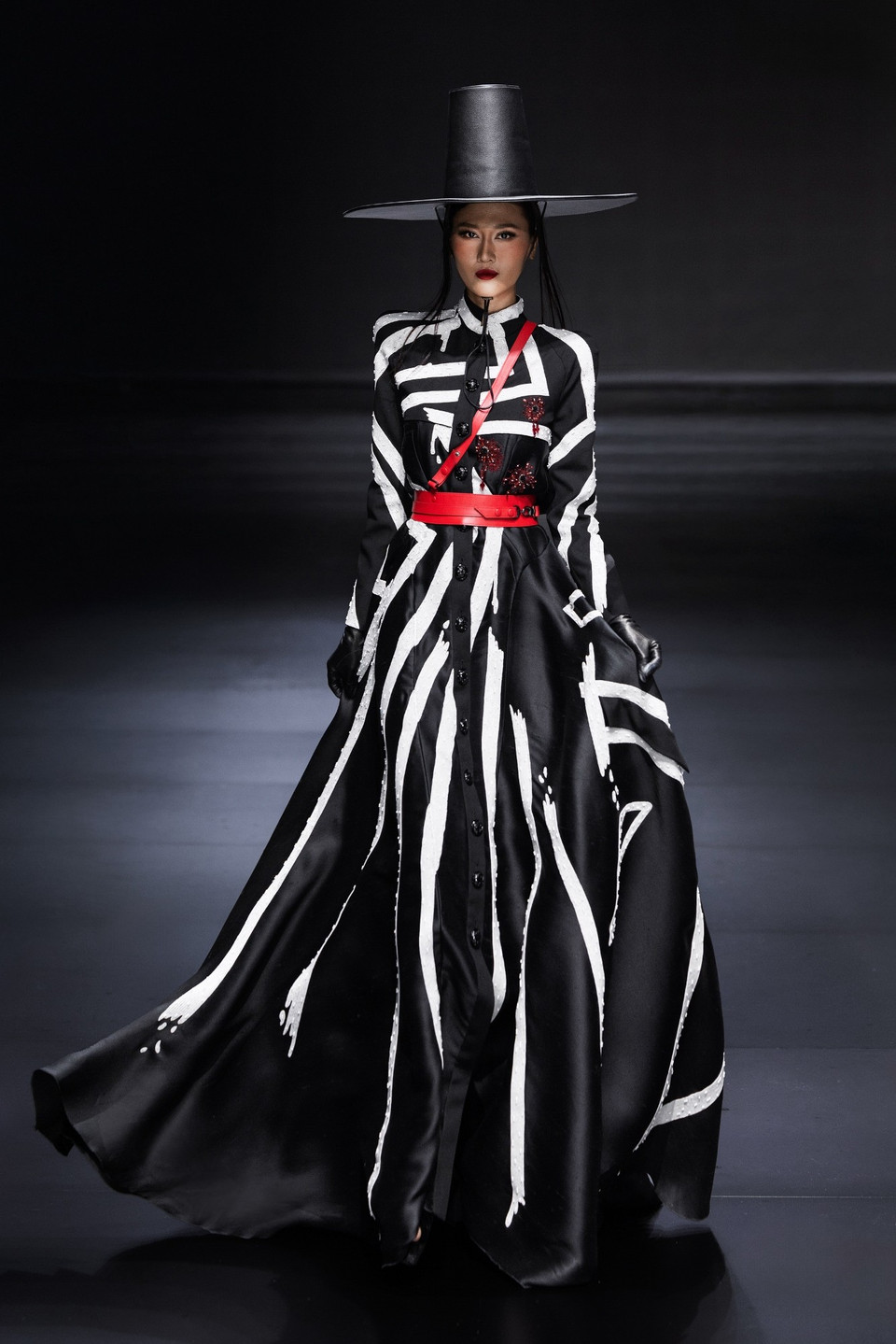 Âm nhạc biến hóa từ những nhịp trống dồn dập đến giai điệu mềm mại, khiến tiết tấu catwalk cũng chuyển biến linh hoạt, khi thì dứt khoát, khi lại mơ màng, như thể từng bước chân là một câu chuyện thị giác đang được kể bằng chất liệu vải và dáng vóc. (Ảnh: CTV/Vietnam+)