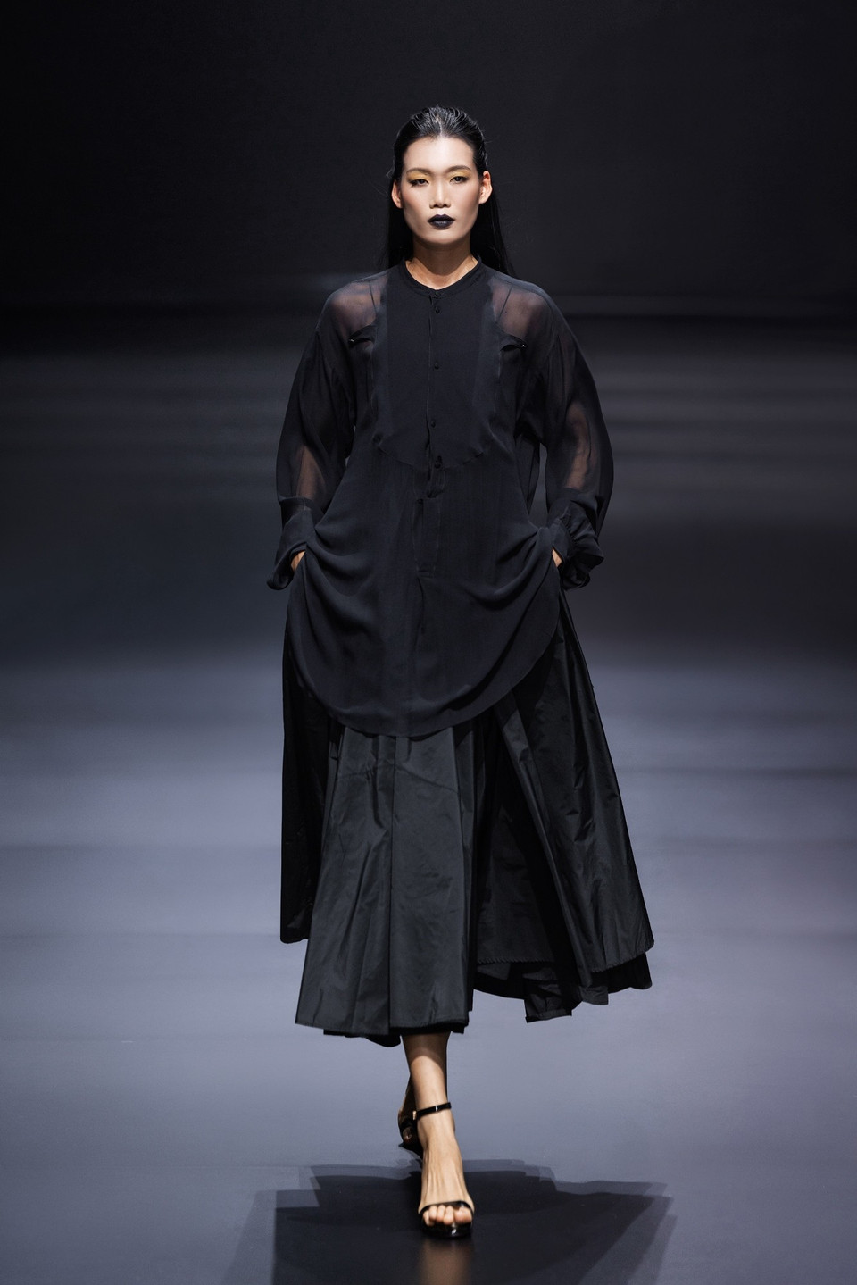 Tựa như một bản nhạc thị giác, “Silence” mở màn bằng những thiết kế sắc trắng tinh khôi, biểu tượng cho khởi nguyên và sự trong trẻo, lặng lẽ dẫn dắt khán giả qua từng cung bậc cảm xúc, để rồi kết lại bằng sắc đen sâu thẳm, như một nốt trầm ngân dài, để lại dư âm khó quên. (Ảnh: CTV/Vietnam+)