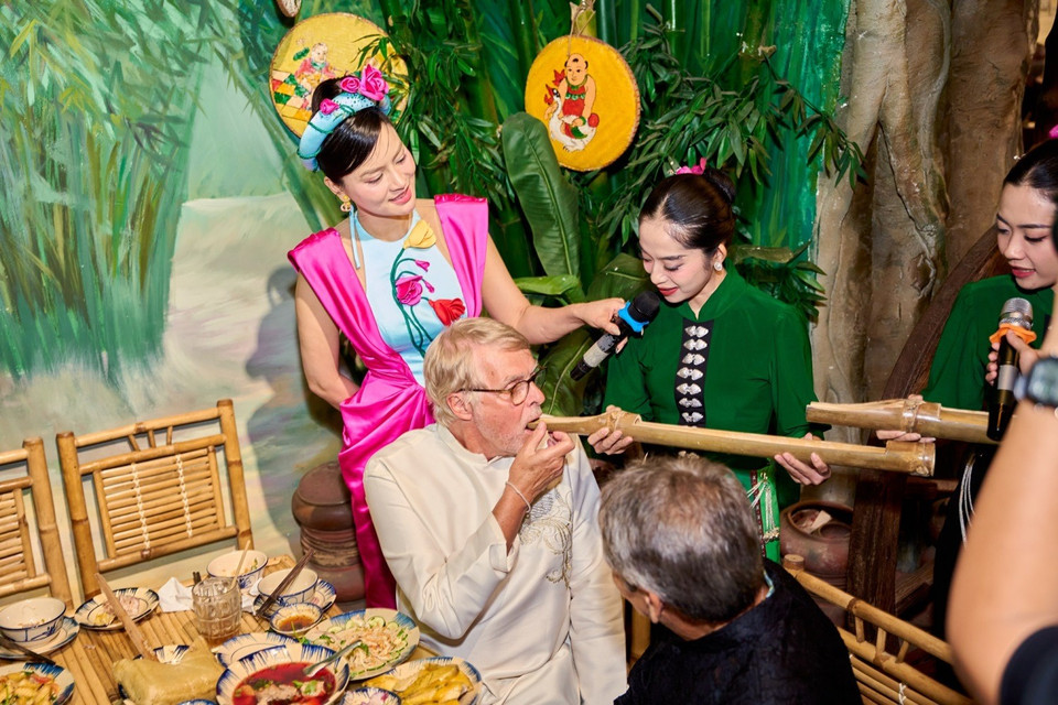 Khách quốc tế trải nghiệm uống rượu kiểu Tây Bắc. (Ảnh: CTV/Vietnam+)