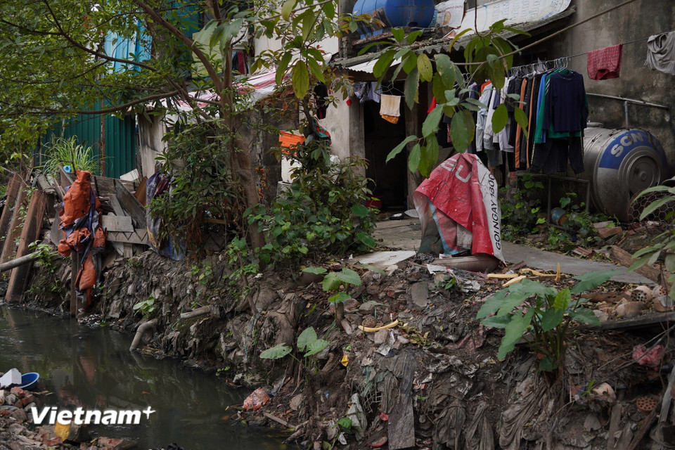 Người dân hàng ngày phải gồng mình sống bên dòng mương đen kịt, chịu đựng cảnh ô nhiễm triền miên. Liệu những “bể chứa rác lộ thiên” này sẽ còn tồn tại đến bao giờ? (Ảnh: Vân Anh/Vietnam+)