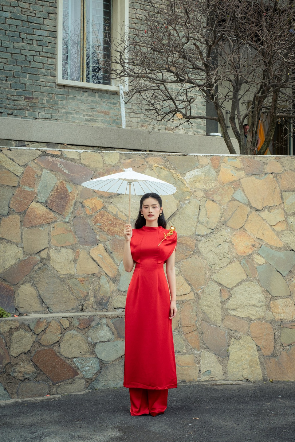 Màu đỏ rực rỡ làm nổi bật làn da trắng, những đường xẻ tà tinh tế tôn lên vóc dáng thanh mảnh của người đẹp. Trong từng khung hình, Ý Nhi không chỉ thể hiện nét đẹp truyền thống mà còn toát lên khí chất hiện đại, tự tin. (Ảnh: CTV/Vietnam+)