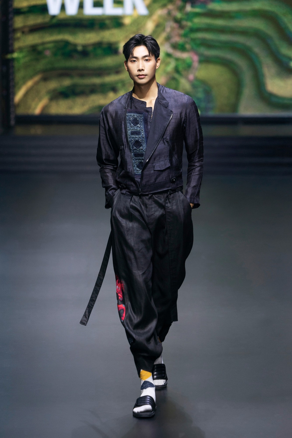 “Mã Đáo” chất chứa nhiều tầng ý nghĩa, bắt đầu từ những mảnh vải thổ cẩm được chế tác từ chiếc váy của bà con dân tộc thiểu số, cho đến cách Vũ Việt Hà dành hết tâm huyết thực hiện từng công đoạn như dệt, nhuộm, khâu tay…. Thậm chí, chiếc nút áo cũng được đúc khuôn thủ công như một cách gìn giữ bản sắc văn hóa Việt Nam. (Ảnh: CTV/Vietnam+)