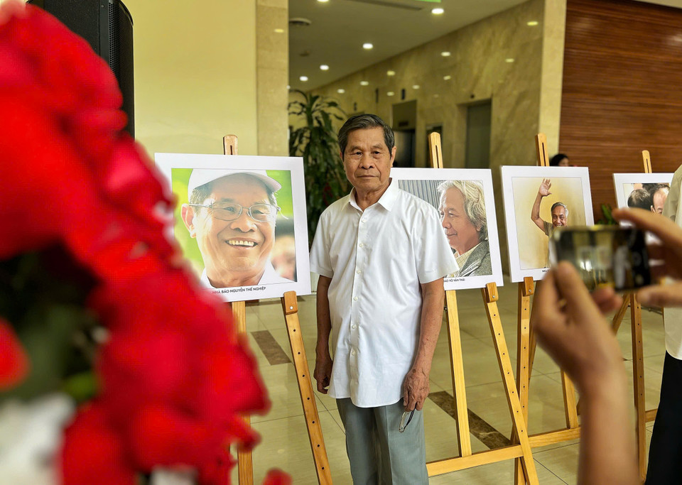 Nhà báo Nguyễn Thế Nghiệp bên bức chân dung của mình. (Ảnh: Mai Mai/Vietnam+)