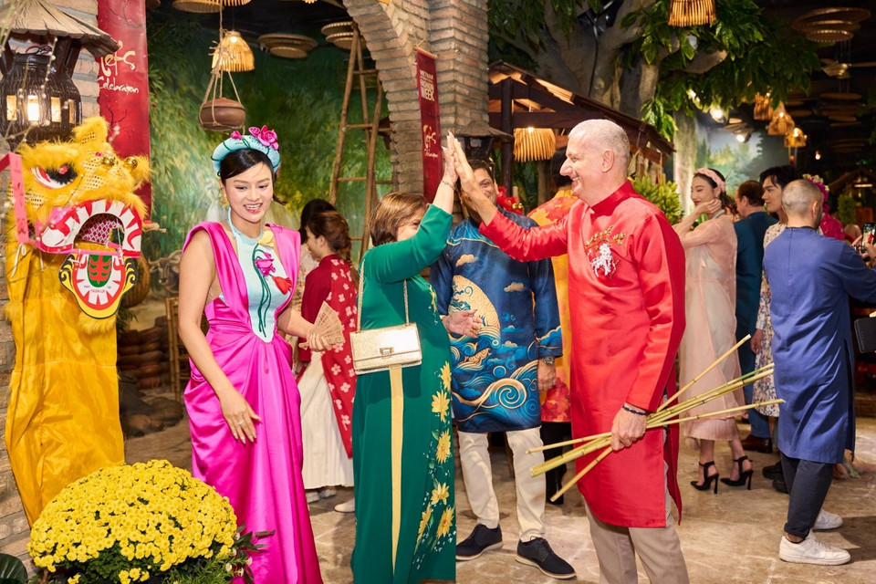 Trong không gian ngập tràn sắc xuân, các vị khách mời đã vô cùng háo hức và thích thú khi được trải nghiệm nhiều hoạt động thú vị trong ngày Tết cổ truyền Việt Nam như gói bánh chưng, ném còn, múa sạp, viết câu đối, đập niêu đất và hòa cùng những điệu múa, câu hát dân gian miền Bắc. (Ảnh: CTV/Vietnam+)