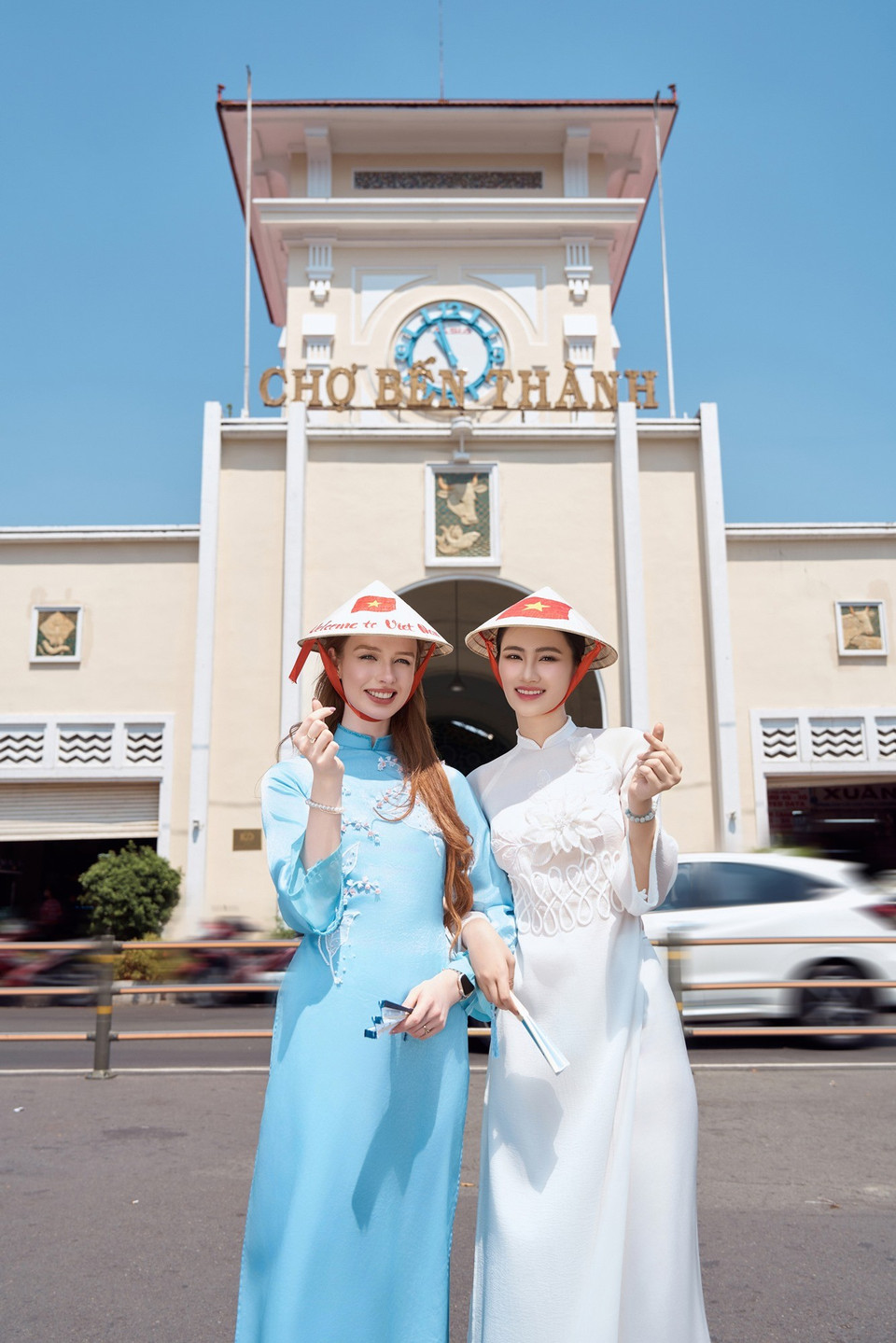 Hai người đẹp cùng biểu tượng Chợ Bến Thành của thành phố Sài Gòn sôi động. (Ảnh: CTV/Vietnam+)