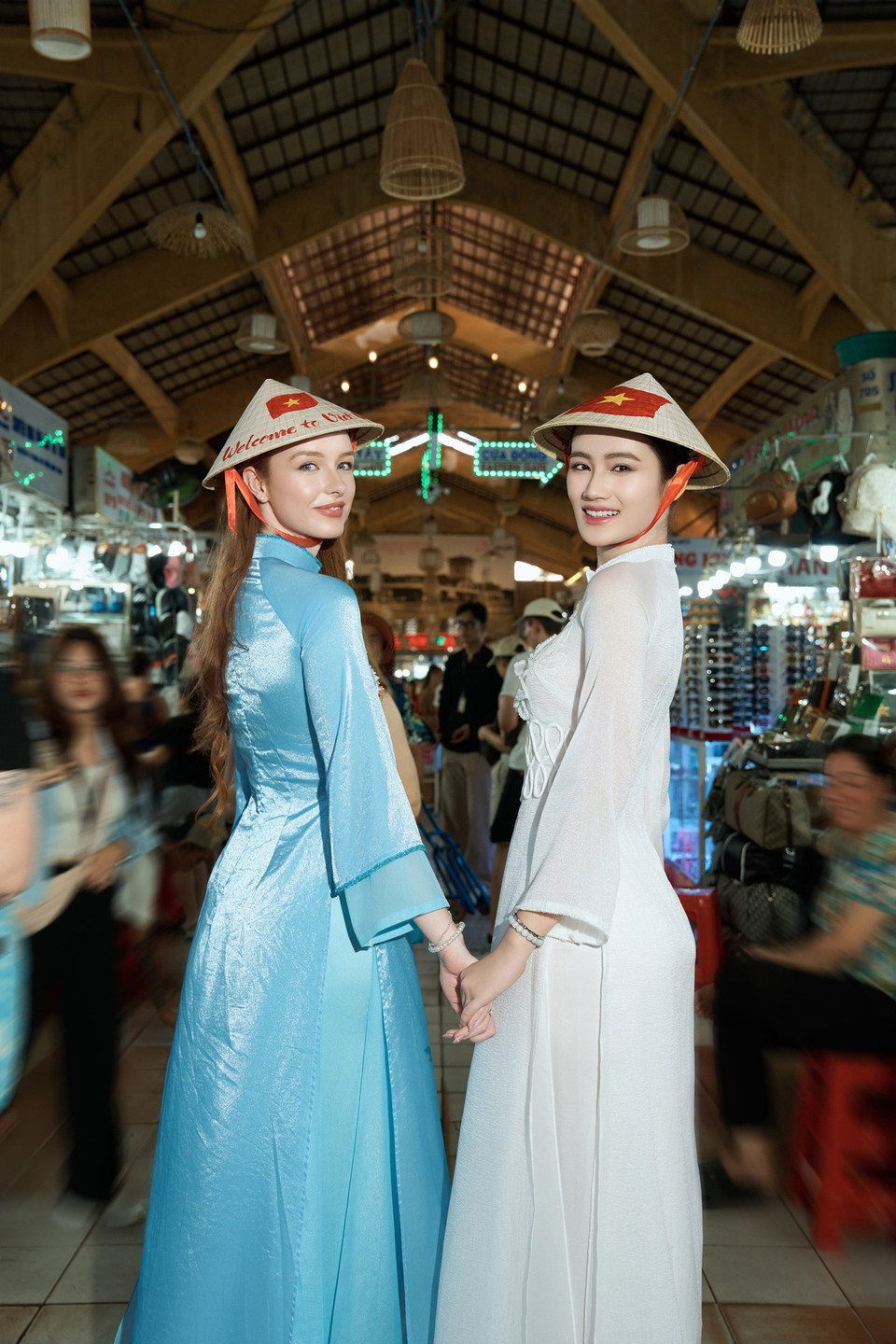 Sự xuất hiện của hai Hoa hậu tại Chợ Bến Thành thu hút sự chú ý của người dân. (Ảnh: CTV/Vietnam+)