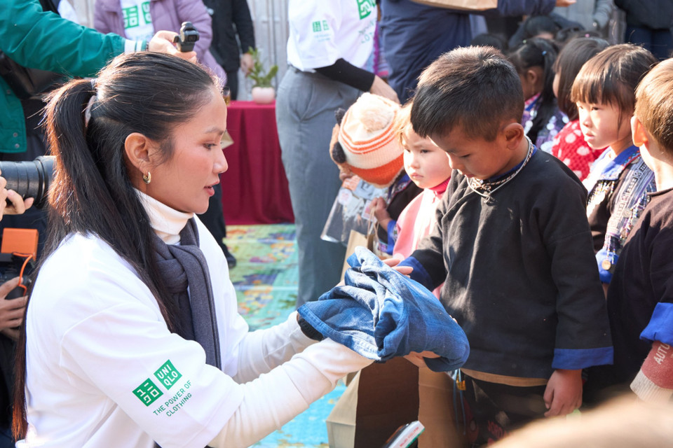Cô còn trực tiếp mặc thử áo cho các em nhỏ. (Ảnh: CTV/Vietnam+)