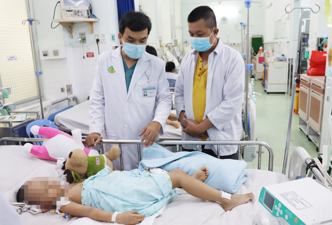 Bác sỹ Bệnh viện Nhi đồng 2 điều trị cho trẻ mắc bệnh tay chân miệng. (Ảnh: TTXVN phát) Cả nước ghi nhận hơn 49.000 trường hợp mắc bệnh tay chân miệng ảnh 1
