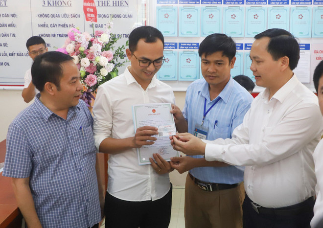Lãnh đạo bảo hiểm xã hội trao giấy khai sinh và thẻ bảo hiểm y tế theo dịch vụ công liên thông. (Ảnh: PV/Vietnam+) Trẻ đầu tiên được cấp giấy khai sinh và thẻ bảo hiểm y tế cùng lúc ảnh 1