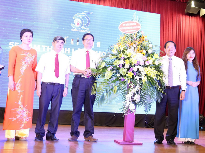 Ông Trương Minh Tuấn, Ủy viên Trung ương Đảng, Bộ trưởng Bộ Thông tin và Truyền thông tặng hoa chúc mừng Khoa Báo chí. (Ảnh: Anh Linh/TTXVN phát) "Cái nôi đào tạo" báo chí, truyền thông tích cực hội nhập quốc tế ảnh 1
