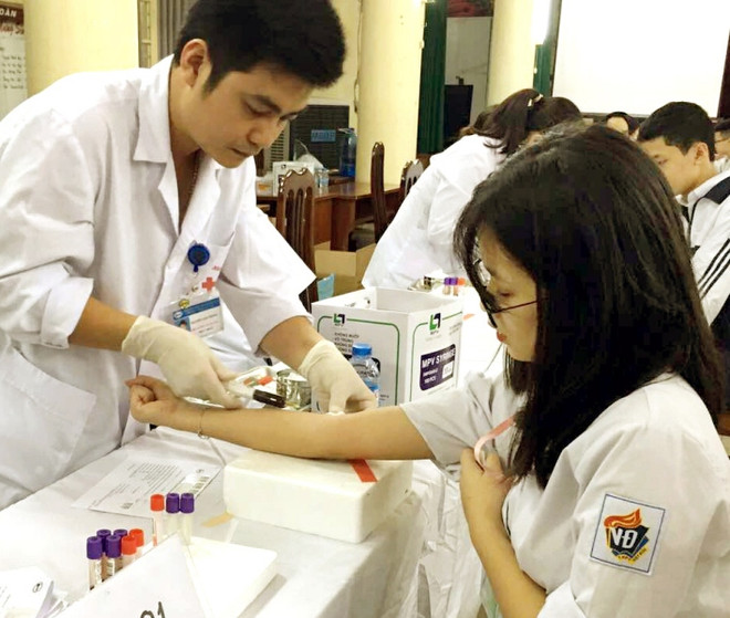 Nhân viên y tế lấy máu xét nghiệm. (Ảnh: Dương Ngọc/TTXVN) Sẽ liên thông kết quả xét nghiệm giữa các bệnh viện từ năm 2018 ảnh 1
