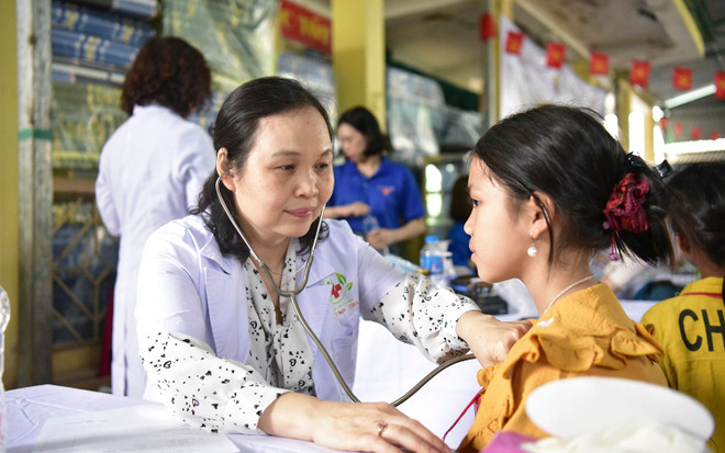 Bác sĩ khám tổng quát cho một học sinh. (Ảnh: PV/Vietnam+) kham be.jpg