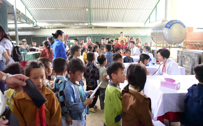Học sinh xếp hàng chờ đến lượt khám. (Ảnh: PV/Vietnam+) xep hanb.jpg