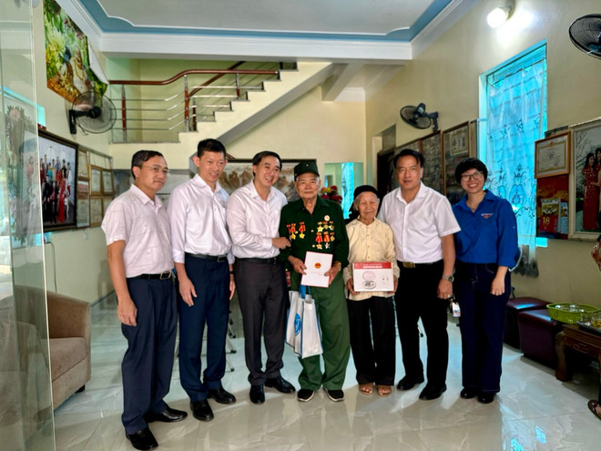 Lãnh đạo Bộ Y tế và các đại diện thăm và tặng quà cho gia đình chính sách. (Ảnh: PV/Vietnam+) chinh sach.jpg