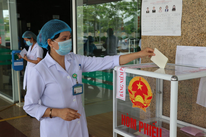 Nhân viên y tế Bệnh viện Bệnh Nhiệt đới Trung ương cơ sở 2 tham gia bỏ phiếu. (Ảnh: PV/Vietnam+) Niềm tin của cử tri qua những lá phiếu từ bệnh viện đang phong tỏa ảnh 3
