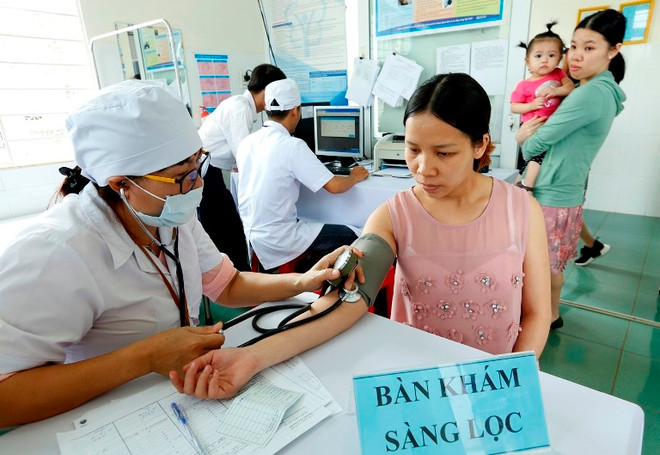 Nhân viên y tế khám sàng lọc tiêm chủng cho người dân. (Ảnh: TTXVN) Tiêm bổ sung vắcxin cho trẻ em tại 6 tỉnh nhiều nguy cơ mắc sởi ảnh 1