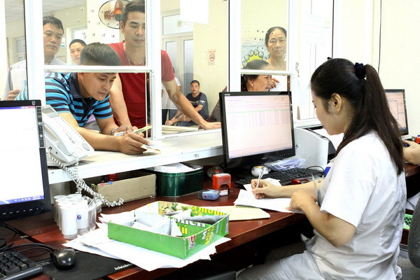 Nhân viên y tế làm các thủ tục khám chữa bệnh cho người dân. (Ảnh: TTXVN/Vietnam+) Chi phí y tế dành cho mỗi người khoảng 1 triệu đồng/năm ảnh 1