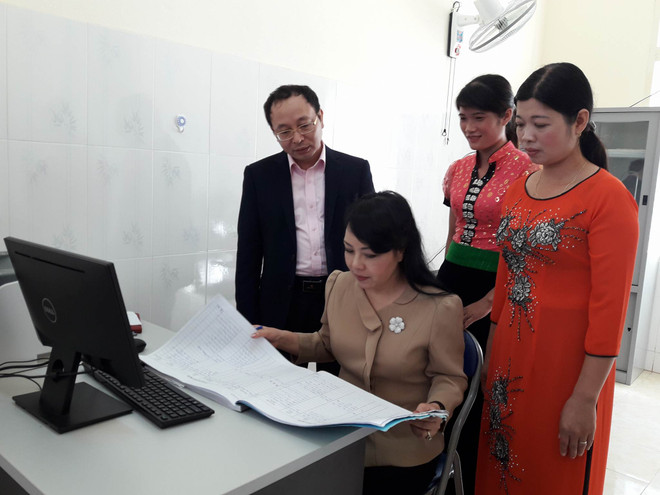 Bộ trưởng Bộ Y tế kiểm tra sổ khám bệnh tại Trạm Y tế Xã Chiềng Yên. (Ảnh: PV/vietnam+) Bộ Y tế: 50% số trạm y tế xã trên cả nước chưa đạt chuẩn quốc gia ảnh 2