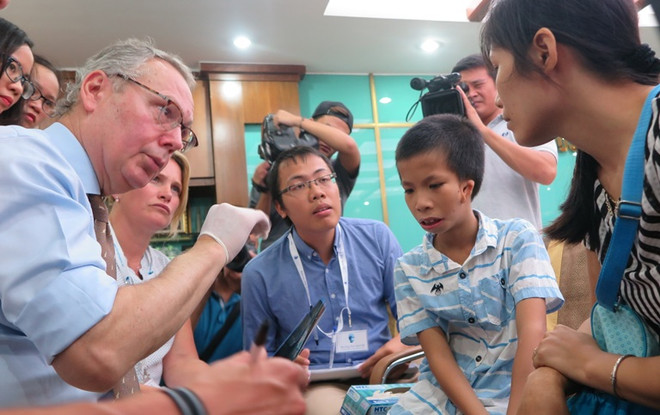 Chuyên gia thăm khám cho trường hợp bệnh nhân bị dị tật hàm mặt. (Ảnh: PV/Vietnam+) Phẫu thuật từ thiện cho trẻ dị tật bẩm sinh có hoàn cảnh khó khăn ảnh 1