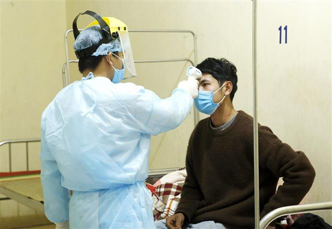 Nhân viên y tế đo thân nhiệt cho các trường hợp bị cách ly. (Ảnh: Dương Ngọc/TTXVN) Thành lập Tổ công tác đặc biệt giúp Vĩnh Phúc kiểm soát dịch Covid-19 ảnh 1