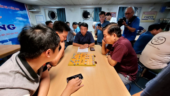 Các thành viên suy tư với các nước cờ. (Ảnh: PV/Vietnam+) vnp co tuong 2.jpg