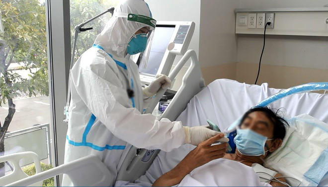 Nhân viên y tế chăm sóc cho bệnh nhân mắc COVID-19. (Ảnh: PV/Vietnam+) Thứ trưởng Bộ Y tế: 'Chúng ta đã thấy ánh sáng cuối đường hầm' ảnh 1