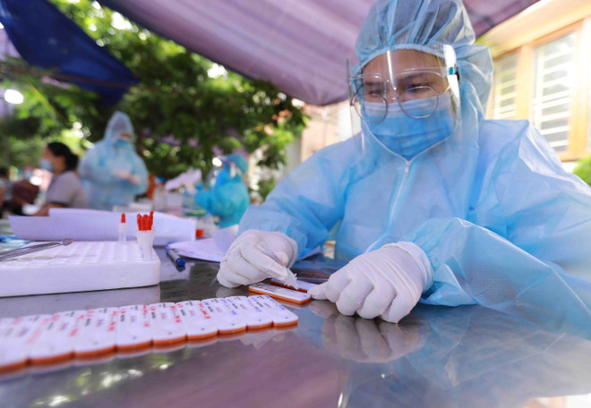 Nhân viên y tế làm công tác xét nghiệm. (Ảnh: TTXVN/Vietnam+) Chiều 14/9: Hà Nội thêm 14 ca mắc COVID-19 tại khu vực phong tỏa ảnh 1