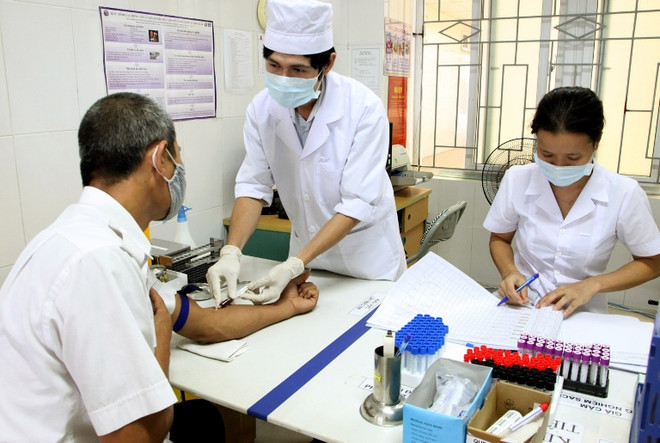 Nhân viên y tế xét nghiệm tự nguyện điều trị cho người nhiễm HIV. (Ảnh: TTXVN/Vietnam+) Quy định việc thanh toán, hỗ trợ chi phí thuốc kháng virus HIV ảnh 1