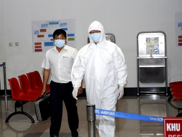 Diễn tập tình huống nhân viên đưa một hành khách nghi nhiễm Ebola ra xe cứu thương. (Ảnh: TTXVN) Thành lập 4 đội đáp ứng nhanh phòng, chống dịch Ebola ảnh 1