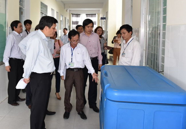 Đoàn kiểm tra của Bộ Y tế kiểm tra tủ lạnh đựng vắcxin tại Trung tâm y tế huyện Điện Bàn, tỉnh Quảng Nam. (Ảnh: PV/Vietnam+) Gần 5 triệu trẻ đã được tiêm vắcxin sởi-Rubella an toàn ảnh 1