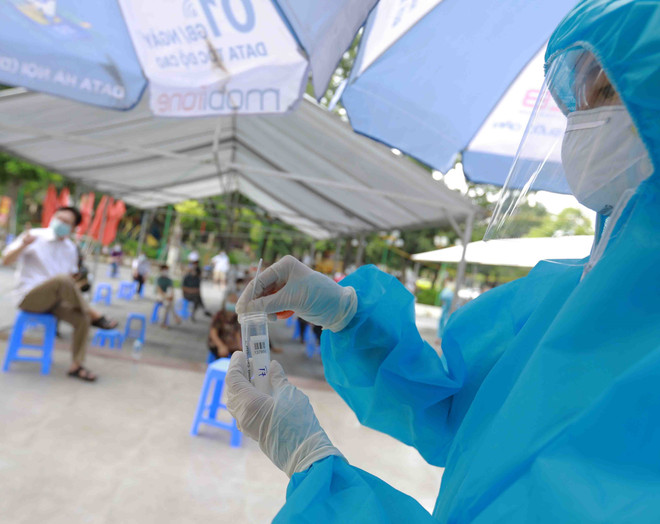 Nhân viên y tế làm công tác xét nghiệm mẫu để phát hiện ca mắc COVID-19. (Ảnh: TTXVN/Vietnam+) Hà Nội ghi nhận thêm 28 ca mắc COVID-19, trong đó 10 ca tại cộng đồng ảnh 1