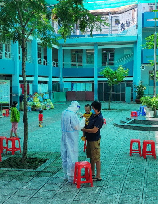 Bác sỹ khám cho em bé trong gia đình cả 5 người đều mắc COVID-19. (Ảnh: PV/Vietnam+) Tâm sự của bác sỹ về 'cuộc sống khác' ở khu cách ly điều trị COVID-19 ảnh 2