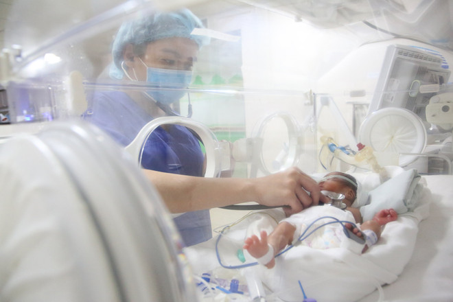 Nhân viên y tế chăm sóc cho trẻ sơ sinh. (Ảnh: PV/Vietnam+) Việt Nam đẩy mạnh chăm sóc sức khỏe sinh sản vị thành niên, thanh niên ảnh 1