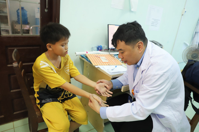 Bác sĩ da liễu khám cho trẻ em trên đảo Lý Sơn. (Ảnh: PV/Vietnam+) kham cho be.jpg
