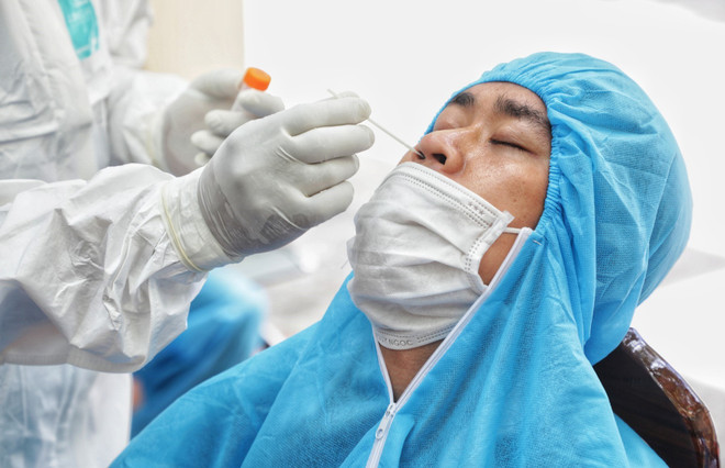 Nhân viên y tế lấy mẫu xét nghiệm COVID-19 cho người dân. (Ảnh: Thành Đạt/TTXVN) Găng tay khi lấy mẫu xét nghiệm COVID-19 cho người dân chỉ dùng 1 lần ảnh 1