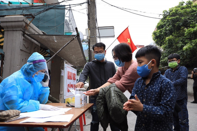Người dân tại khu vực phong toả ở Hà Nội thực hiện các biện pháp phòng chống COVID-19. (Ảnh: Minh Đức/TTXVN) Hà Nội có thông báo về người đã đi, đến, về từ huyện Cẩm Giàng ảnh 1