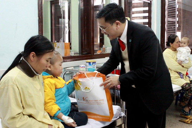 Đại diện Quỹ Hỗ trợ bệnh nhân ung thư Ngày mai tươi sáng tặng quà cho bệnh nhi ung thư. (Ảnh: TTXVN) Hỗ trợ hơn 400 tỷ đồng thuốc điều trị cho bệnh nhân ung thư ảnh 1