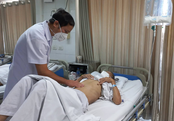 Phó giáo sư Phạm Hoàng Hà thăm khám cho một bệnh nhân ung thư dạ dày. (Ảnh: PV/Vietnam+) Người mắc bệnh ung thư dạ dày tại Việt Nam đang có xu hướng trẻ hóa ảnh 1