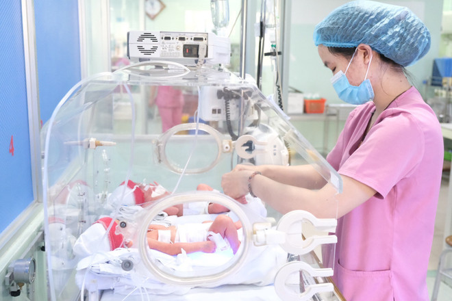 Nhân viên y tế chăm sóc cho trẻ sơ sinh. (Ảnh: TTXVN phát) Chiều cao trung bình của thanh niên Việt Nam tăng sau 20 năm ảnh 1