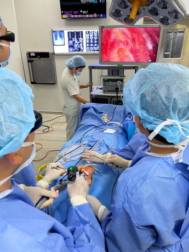 Các bác sỹ thực hiện ca phẫu thuật tuyến giáp cho bệnh nhân qua đường miệng. (Ảnh: PV/Vietnam+) Bác sỹ Bệnh viện E phẫu thuật nội soi tuyến giáp qua đường miệng ảnh 2