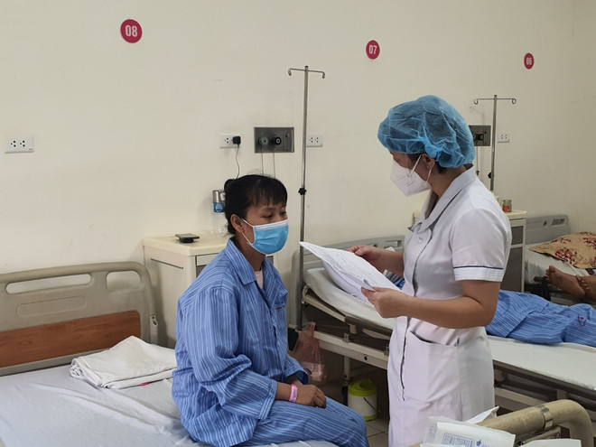 Bác sỹ thăm khám cho bệnh nhân sau phẫu thuật. (Ảnh: PV/Vietnam+) Bác sỹ Bệnh viện E phẫu thuật nội soi tuyến giáp qua đường miệng ảnh 1