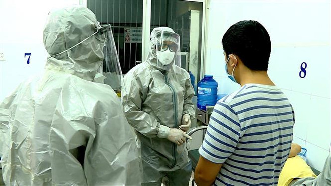 Nhân viên y tế thực hiện các biện pháp nghiệp vụ với bệnh nhân nghi mắc nCoV. (Ảnh: Thành Chung/TTXVN) Bộ Y tế: Thêm 3 ca là công dân Việt Nam dương tính với virus corona ảnh 1