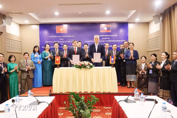 Giáo sư, Tiến sỹ Lê Văn Lợi, Chủ tịch Viện Hàn lâm Khoa học xã hội Việt Nam và Tiến sỹ Anouphap Tounalom, Giám đốc Học viện Chính trị và Hành chính quốc gia Lào trao đổi Biên bản hợp tác khoa học giai đoạn 2026-2030. (Ảnh: Xuân Tú/TTXVN)