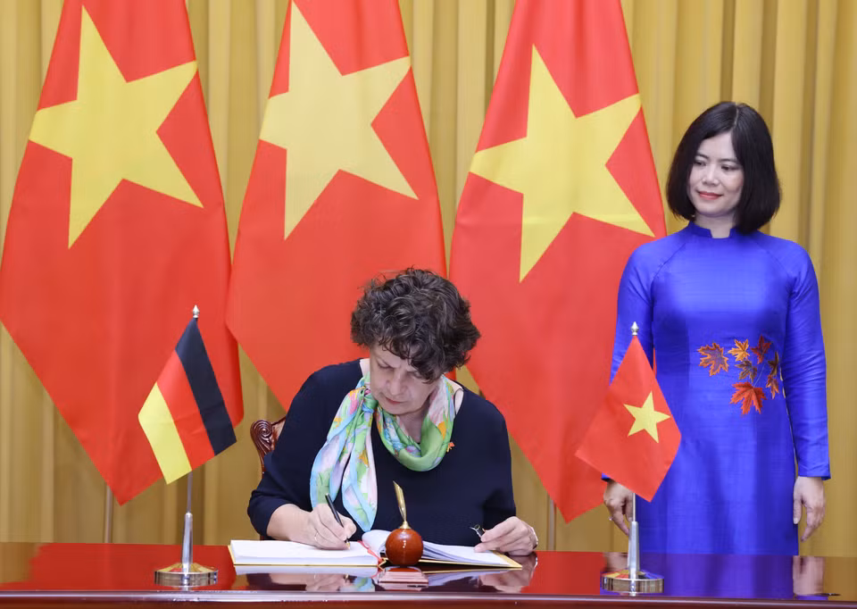 Đại sứ Cộng hòa Liên bang Đức tại Việt Nam Helga Margarete Barth ghi lưu bút. (Ảnh: Lâm Khánh/TTXVN)