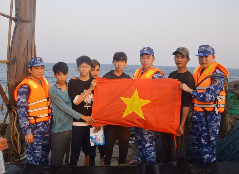 Lực lượng Cảnh sát Biển tặng cờ Tổ quốc cho ngư dân. (Ảnh: Mạnh Thường/TTXVN)