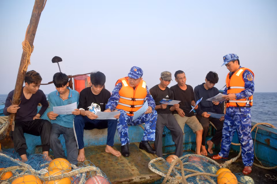 Lực lượng Cảnh sát Biển tuyên truyền pháp luật cho bà con ngư dân Quảng Ngãi trên khu vực biển lân cận đường phân định. (Ảnh: Hoàng Ngọc/TTXVN)