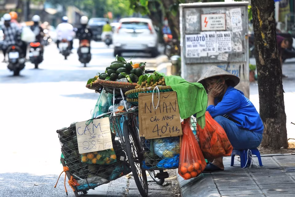 Một người bán hàng mệt mỏi trong thời tiết nắng nóng trưa 28/6/2022. (Ảnh: Hoàng Hiếu/TTXVN)
